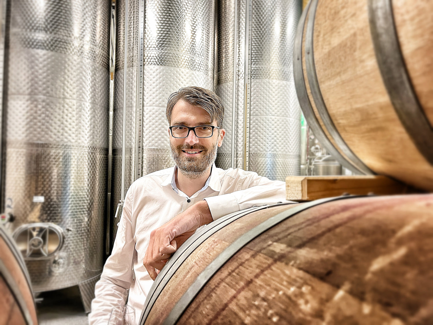 Frederic, Gründer von "alkoholfrei vom Winzer", im Weinkeller bei den Weinfässern